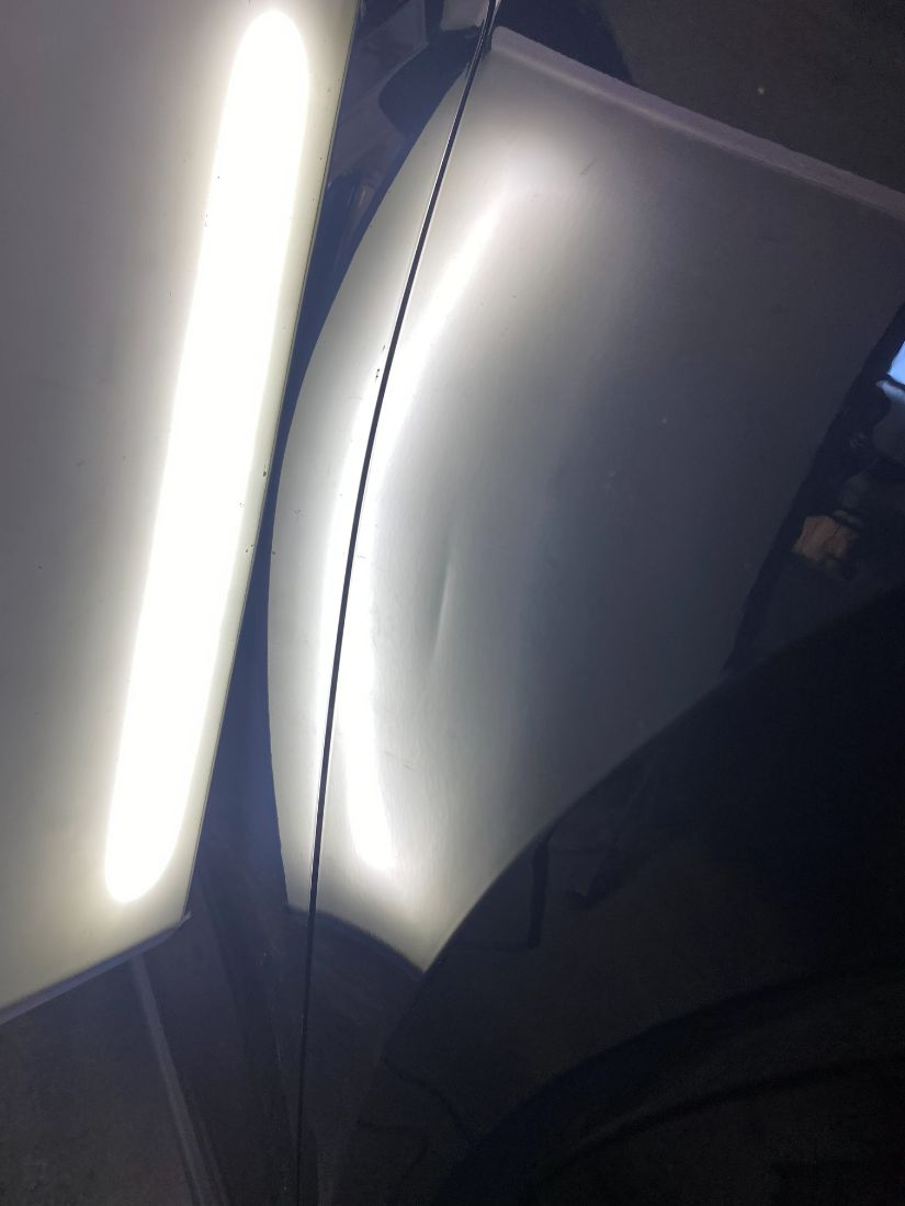 Dent on a silver fender before repair